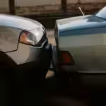 A close-up view showing the aftermath of a rear-end car collision in an outdoor setting.